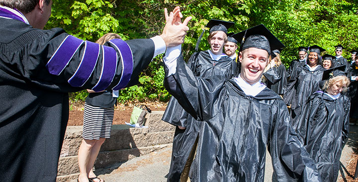 A Ƶ graduate receives a high five from the College's President on Commencement Day